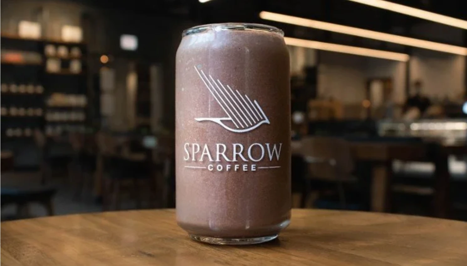 Sparrow Coffee branded glass can with a chocolate drink in the Sparrow café